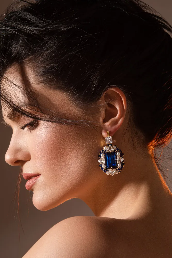 Model wearing statement sapphire-blue drop earrings