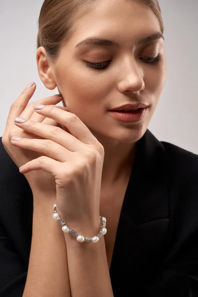 Model wearing a pearl and gold bracelet